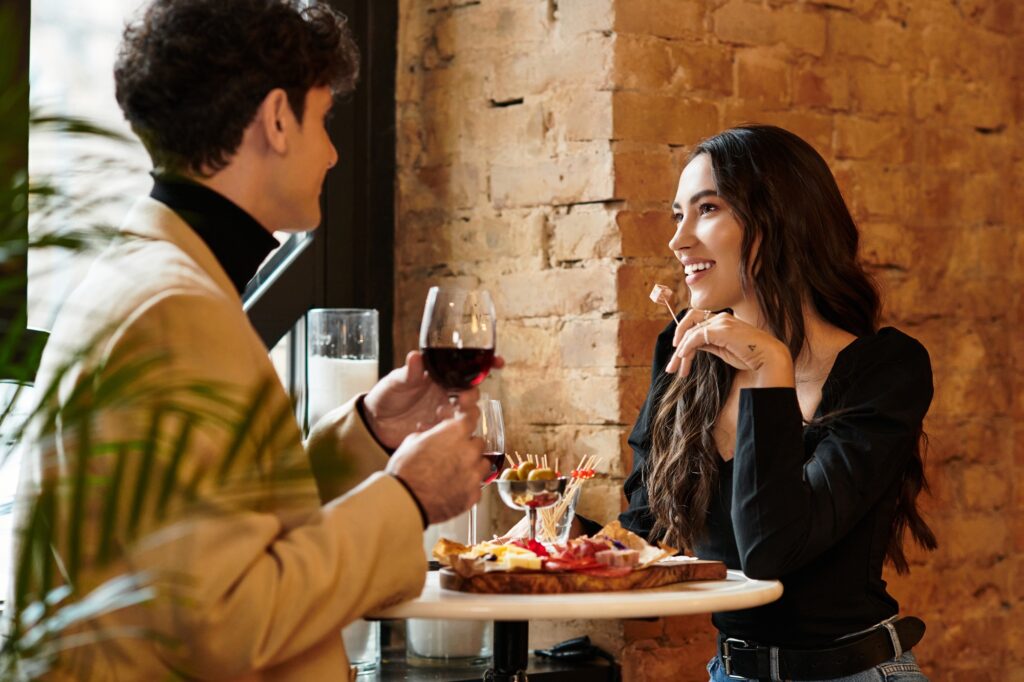 Young couple celebrates their love with wine and delicious dishes in a warm restaurant atmosphere.