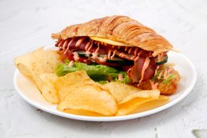 Freshly made Ham, Bacon and Cheese Croissant served with chips