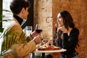 Young couple celebrates their love with wine and delicious dishes in a warm restaurant atmosphere.